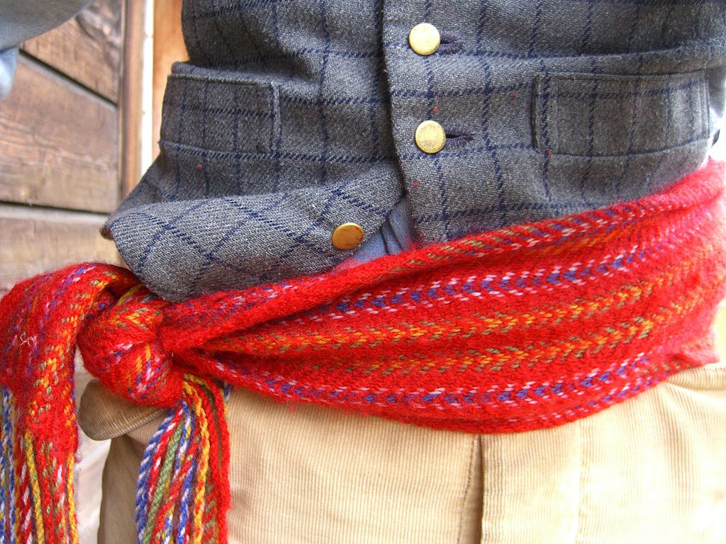 A red sash is tied around a person's waist.